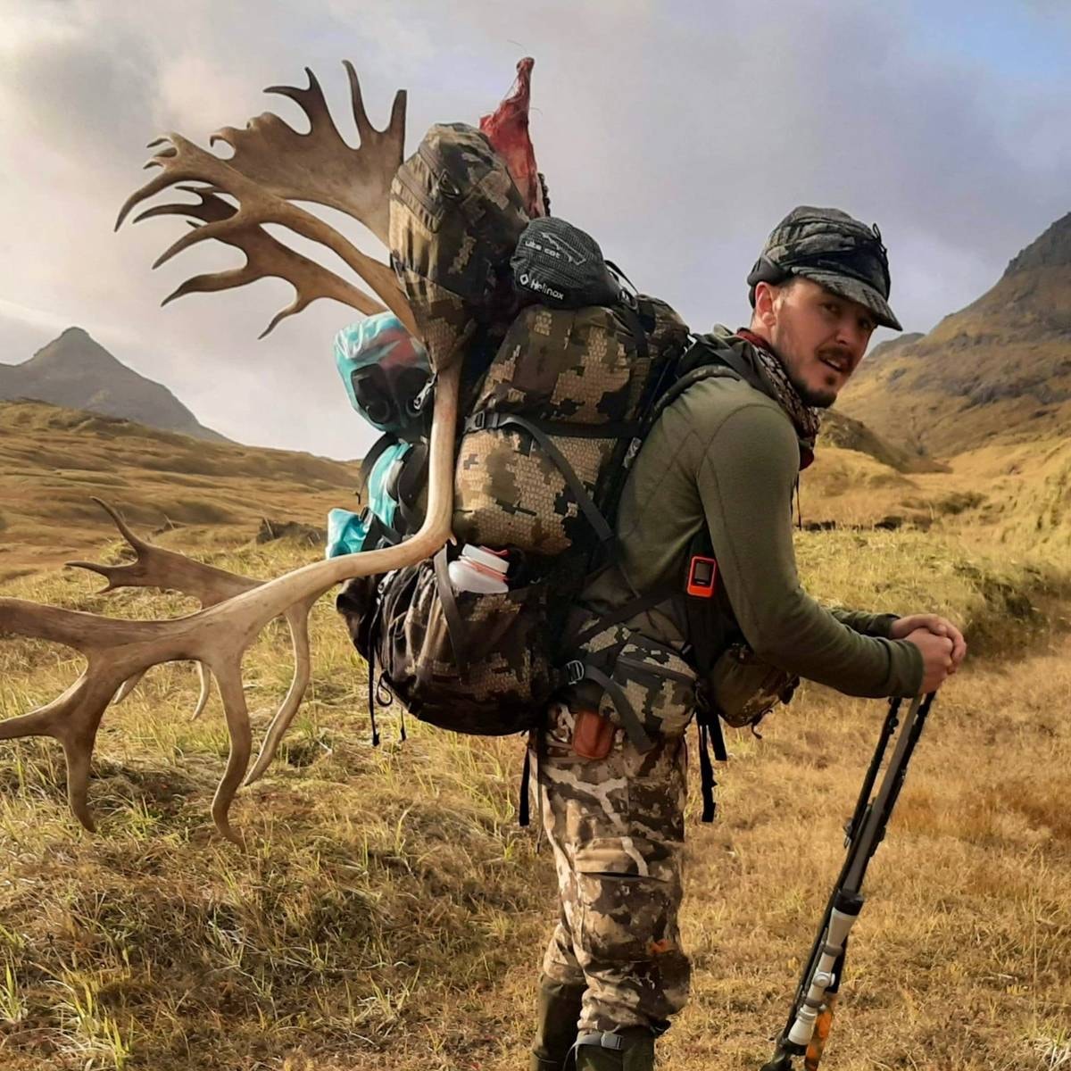 Backpack hunter packing out a Caribou rack on Adak