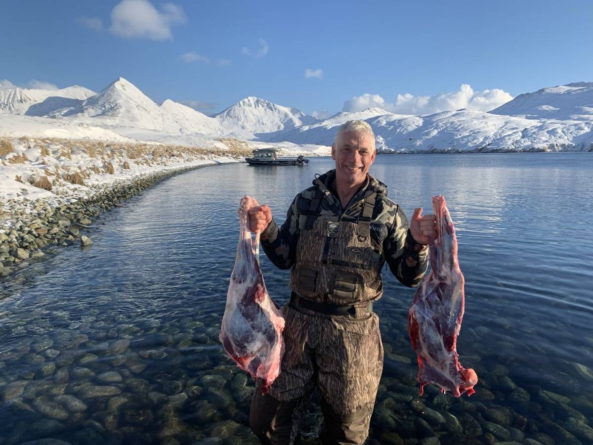 Hunter with Caribou quarters at the cove