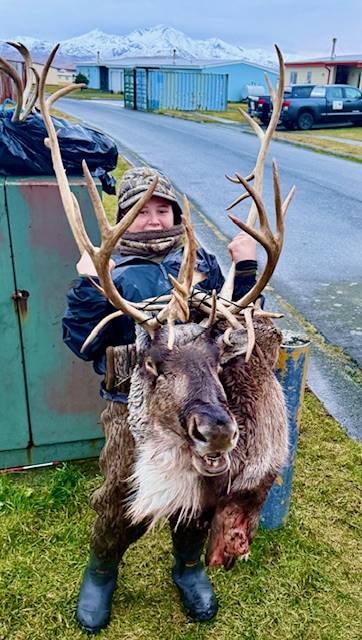 Hunter with trophy Caribou bull, Adak mountains behind