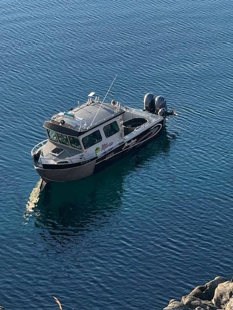 Adak charter boat running across calm blue water