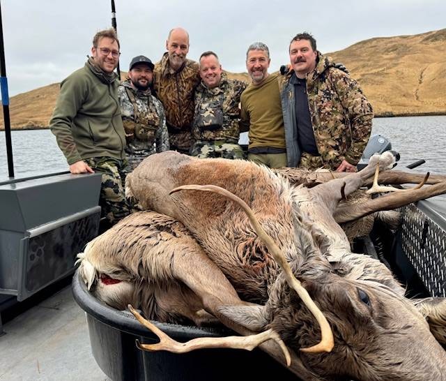 Group of hunters on the Adak Lodge boat with harvested caribou