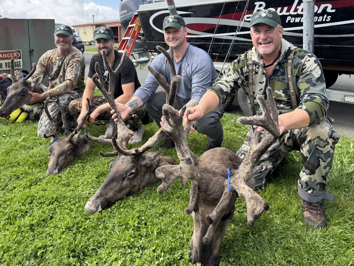 Two hunters posing with a massive Caribou bull