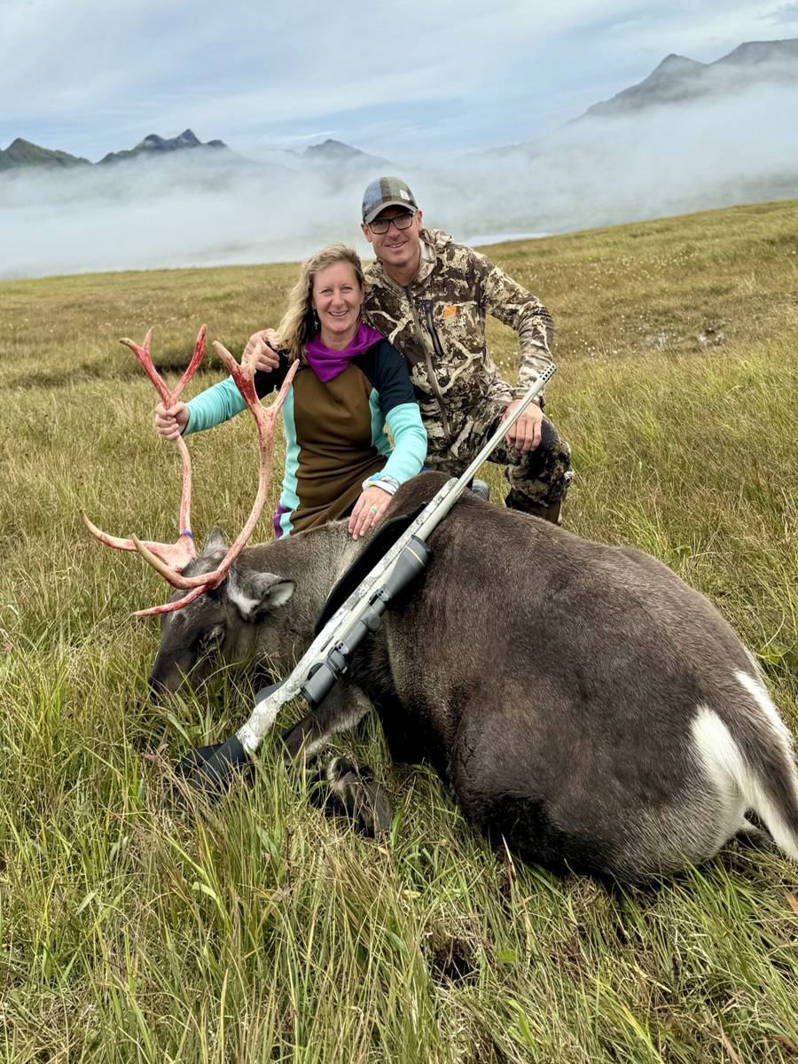 Hunters with a trophy Caribou bull in the Adak fog and mountains