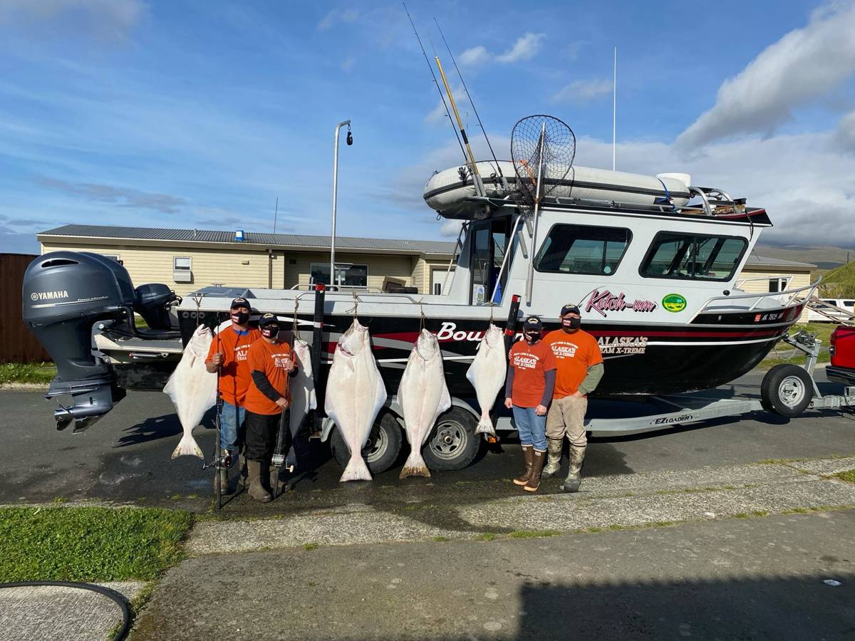 Charter group in orange shirts with four big Halibut hung off the Bowrider